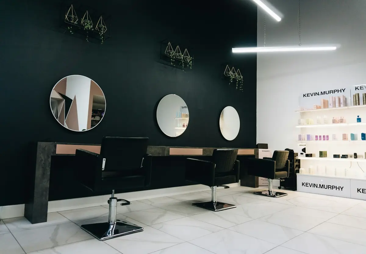 Drie zwarte kappersstoelen voor ronde spiegels in de salon