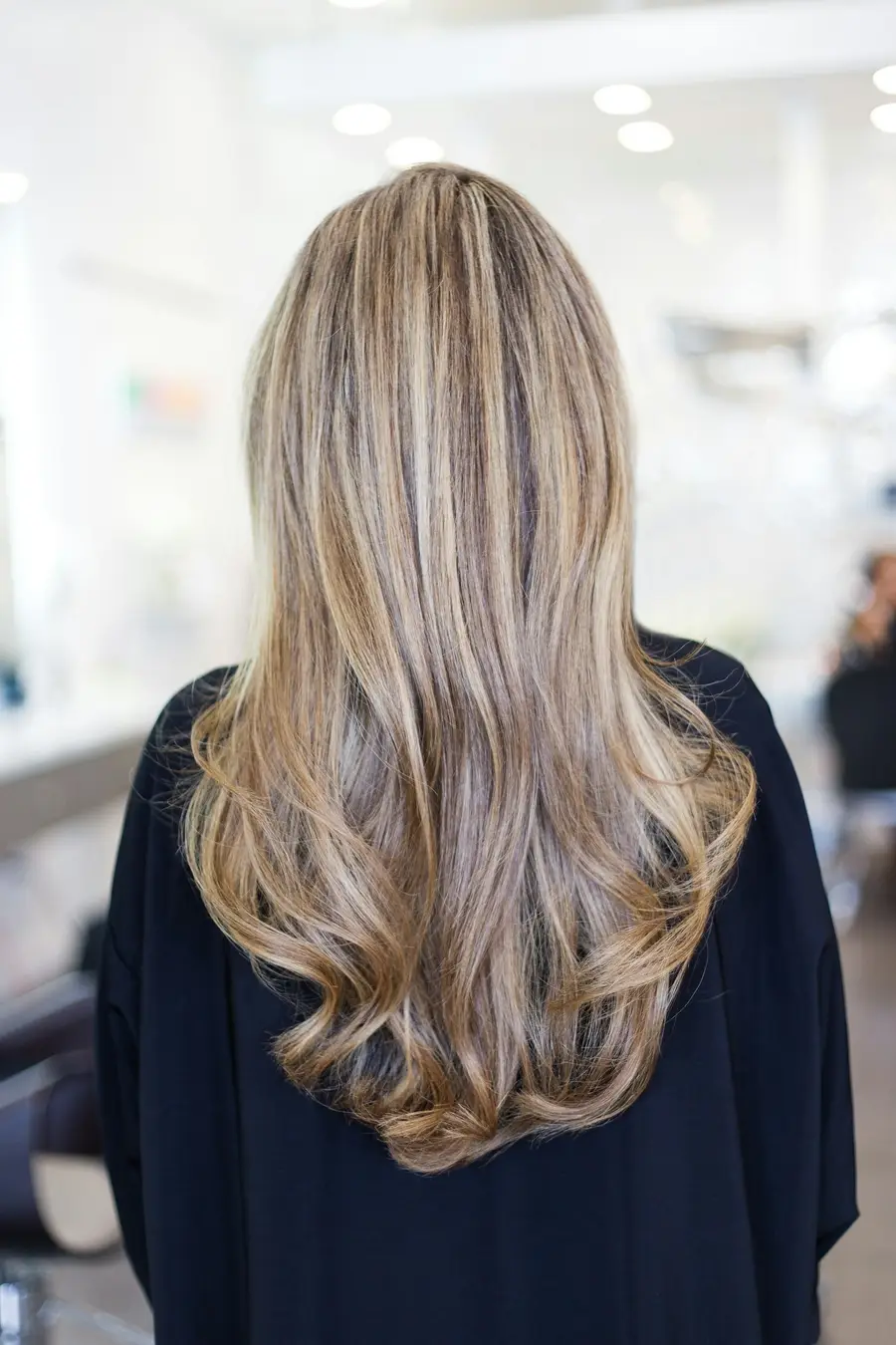 Voor: lang, golvend blond haar, gezien van achteren